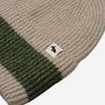 Contrasting stripe and Scottie dog mascot tag on the Knitters Lane Oatmeal Marl Hat with Contrasting Stripe.