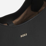 The gold-tone metallic logo on the front of the BOSS Lenah Black Leather New Tote Bag with Metallic Logo.
