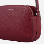 Side view of the Dukes Place Carmine Leather Medium Zip Top Cross Body Bag.