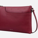 Side view of the Pockets Carmine Red Leather Medium Zip Top EW Cross Body Bag.