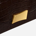 Branded plate hardware on The Belsize Dark Oak Faux Croc Leather Small Flapover Shoulder Bag.