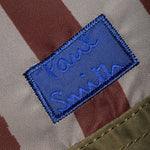 Blue Paul Smith logo patch on the front of the Paul Smith Multistripe Recycled Nylon Adjustable Tote Bag with Signature Logo Patch.