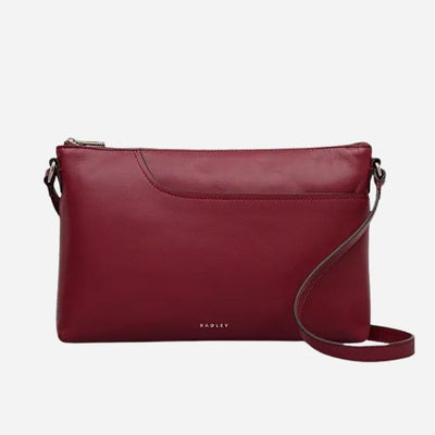 The Pockets Carmine Red Leather Medium Zip Top EW Cross Body Bag by Radley.