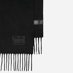 Close up of the edges on the Men's Black Cashmere Scarf with Signature Logo Patch.