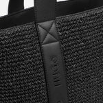The HUGO logo on the BOSS Becky Black Raffia Tote Bag with Embossed Hugo Detailing.