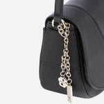 Side view of the charms on the BOSS Salley Black Saddle Bag with Metal Logo.