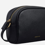 Side view of the Radley The Daily Black Small Zip Top Cross Body Bag.
