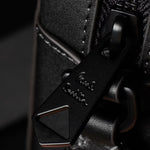 Close up of the zip puller on the Paul Smith Signature Stripe Coated Canvas Flight Bag.