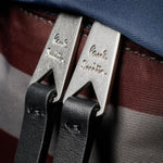Paul Smith signature logo on the silver-tone zips of the Paul Smith Multistripe Recycled Nylon Backpack with Signature Logo Patch.