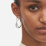 Model wearing Sterling Silver Infinity Earhoops in Large from Georg Jensen.