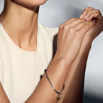 Model wearing Sterling Silver Offspring Bangle with Charm from Georg Jensen.