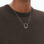 Model wearing the sterling silver Offspring Pendant in medium from Georg Jensen.