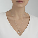 Model wearing Sterling Silver Mercy Medium Pendant from Georg Jensen.