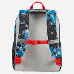 The back view of a backpack featuring a gray mesh back panel, black and blue splatter-patterned shoulder straps, and bright red accents on the top handle, buckle strap, and side buckles.