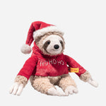 Sanny the Christmas Sloth wearing christmas jumper and santa hat from Steiff.