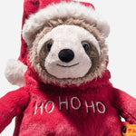 Close up of Sanny the Christmas Sloth wearing christmas jumper and santa hat from Steiff.