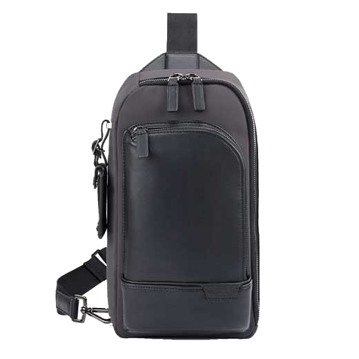 This TUMI leather and canvas sling bag features the brand name embossed on the front.