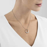 This Georg Jensen Sterling Silver and 18 KT. Rose Gold Offspring Pendant features a clasp closure.